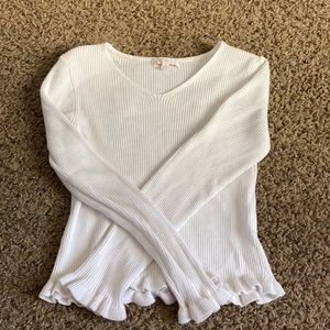 White v-neck long sleeve, frills on bottom of both sleeves and end of shirt